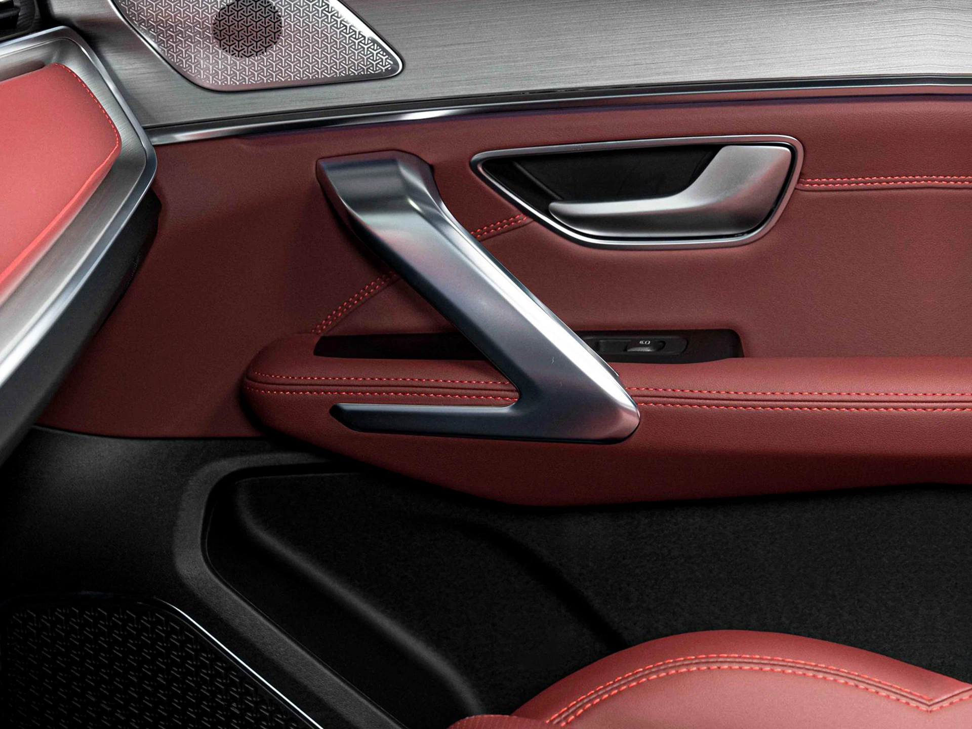 Burgundy door trim with stitching, brushed metal and door handle